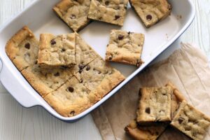 Chocolate Chip Cookie Bars - cut into squares. Some are in the baking pan and some are next to it.