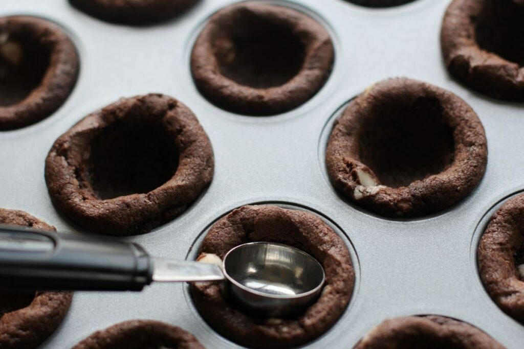 Step 2 - cookies being pressed in by melon baller