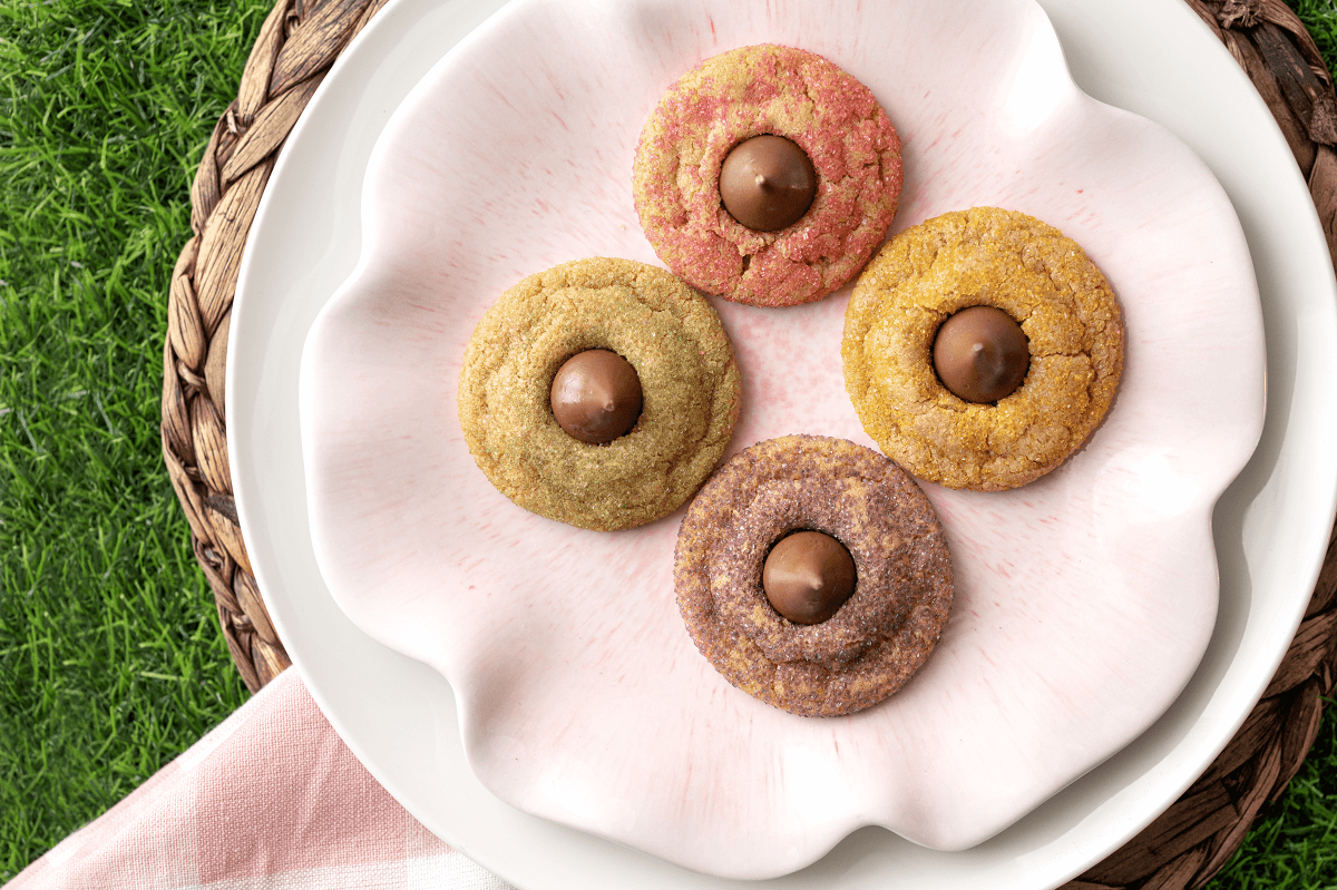 4 Easter Blossom Cookies on a plate and place mat with a grassy background