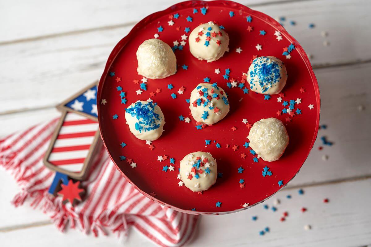Star-Spangled Cookie Truffles on red serving platter surrounded by red, white, and blue decor