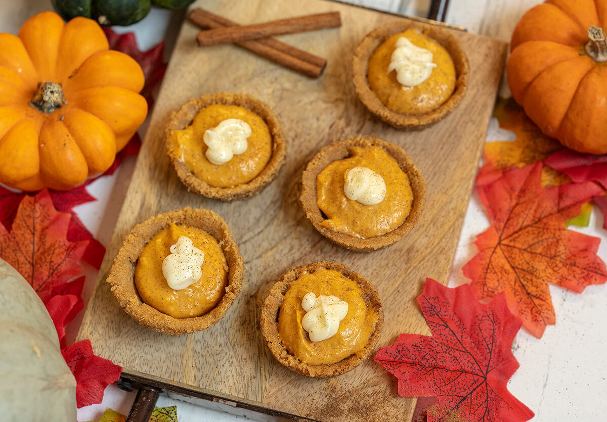 Pumpkin Pie Snickerdoodle Cookie Cups on a serving platter surrounded by fall leaves and pumpkins.